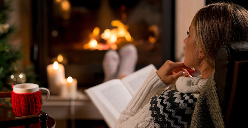 Kurzurlaub Tee und Buch vor dem Kamin